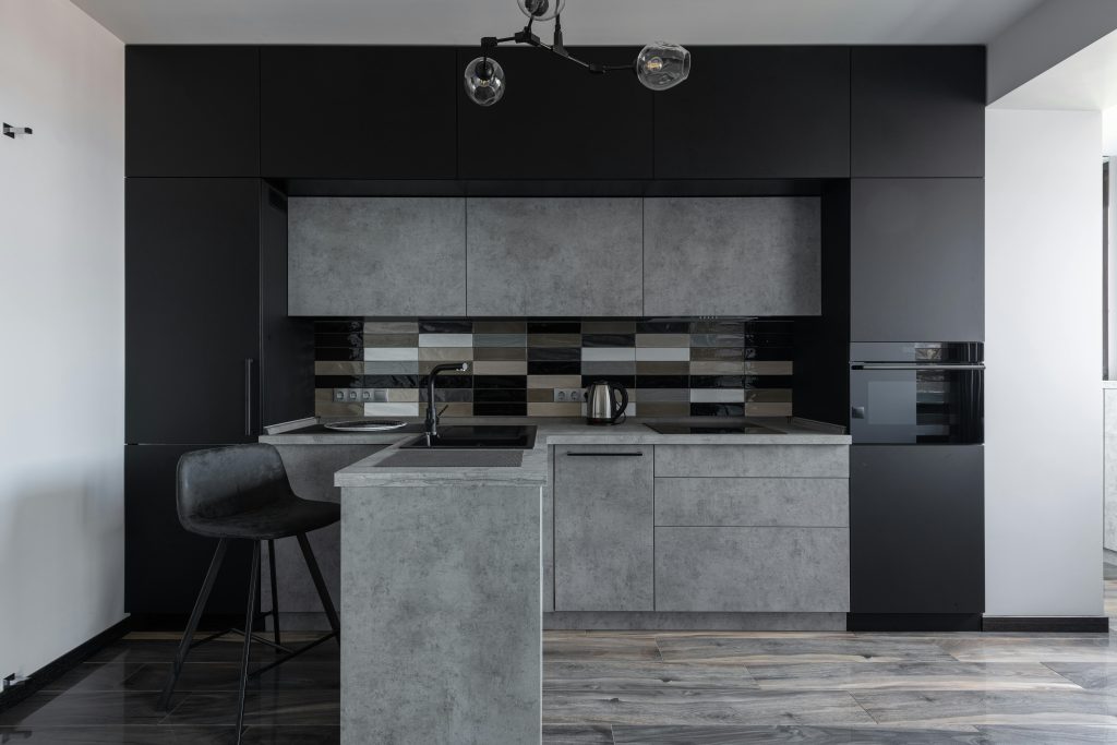 Sleek modern kitchen with black and gray cabinetry, perfect for minimalist decor.